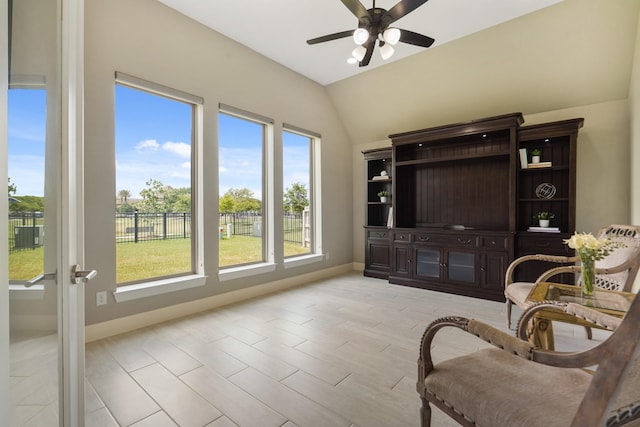 sitting room with lofted ceiling, a ceiling fan, baseboards, and light wood-style flooring