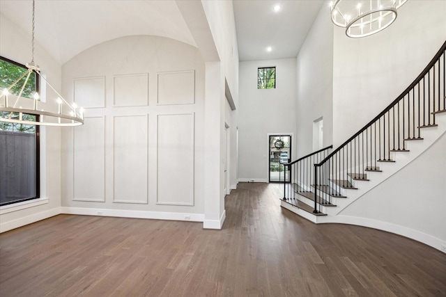 entryway featuring baseboards, a chandelier, and wood finished floors