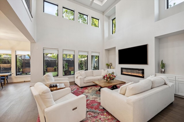 living room featuring wood finished floors and a glass covered fireplace