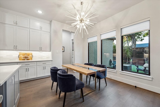 dining area with dark wood-type flooring, baseboards, recessed lighting, and a chandelier