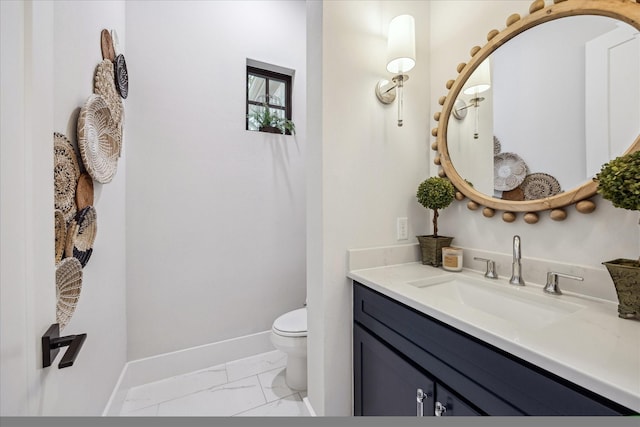 bathroom featuring toilet, baseboards, marble finish floor, and vanity