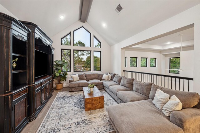living room with high vaulted ceiling, plenty of natural light, visible vents, and beamed ceiling