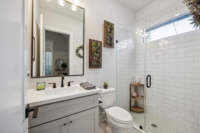 full bath with a shower stall, vanity, and toilet
