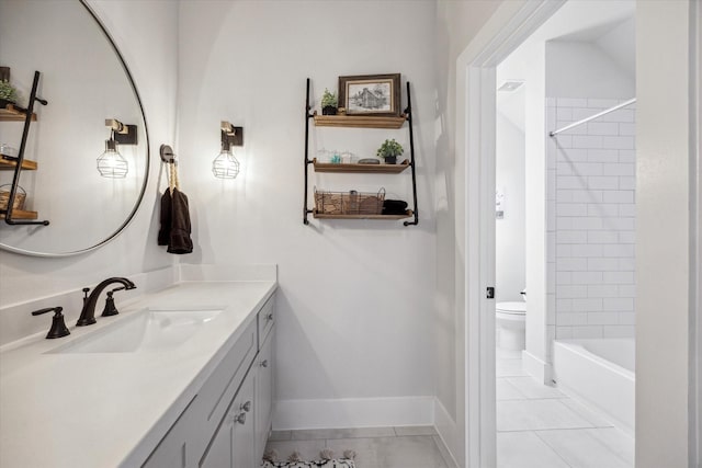 bathroom featuring toilet, tile patterned floors, vanity, and baseboards
