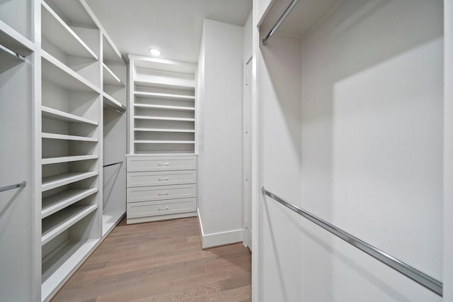 walk in closet with wood finished floors