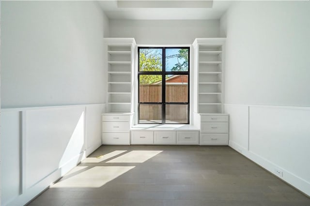 unfurnished bedroom featuring wood finished floors and a wainscoted wall