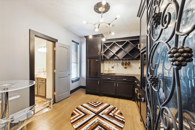 22009 Holly Creek Trl, Tomball, TX 77377 - wine room featuring light wood-style flooring, bar area, a notable chandelier, and visible vents