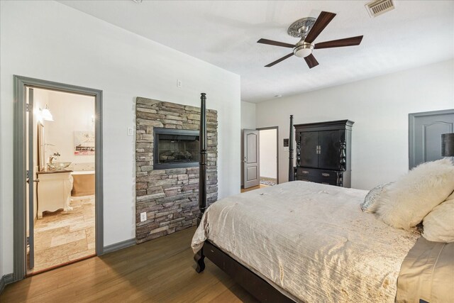 22009 Holly Creek Trl, Tomball, TX 77377 - bedroom featuring wood finished floors, ceiling fan, ensuite bath, and visible vents