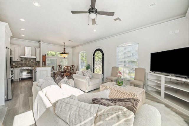 22009 Holly Creek Trl, Tomball, TX 77377 - living area with recessed lighting, light wood-style flooring, crown molding, a ceiling fan, and visible vents