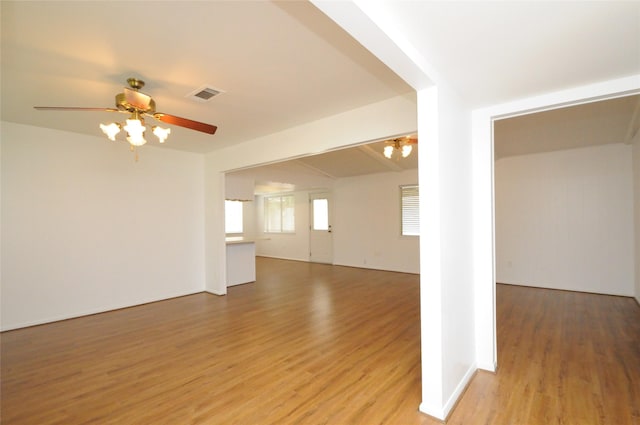 1110 Holly Dr, Conroe, TX 77301 - empty room with visible vents, light wood finished floors, and ceiling fan with notable chandelier