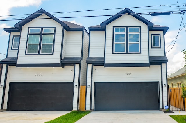 view of front facade featuring a garage, driveway, and fence