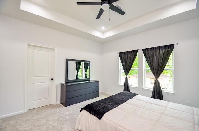 bedroom featuring carpet flooring, a raised ceiling, recessed lighting, baseboards, and a ceiling fan