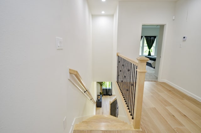 stairs featuring wood finished floors, recessed lighting, and baseboards