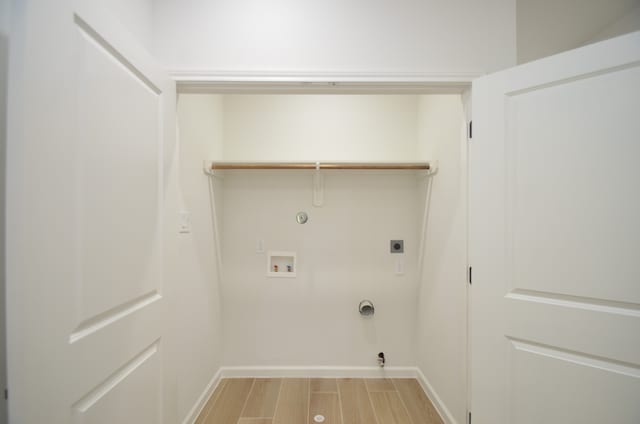 clothes washing area with hookup for a gas dryer, electric dryer hookup, baseboards, and hookup for a washing machine