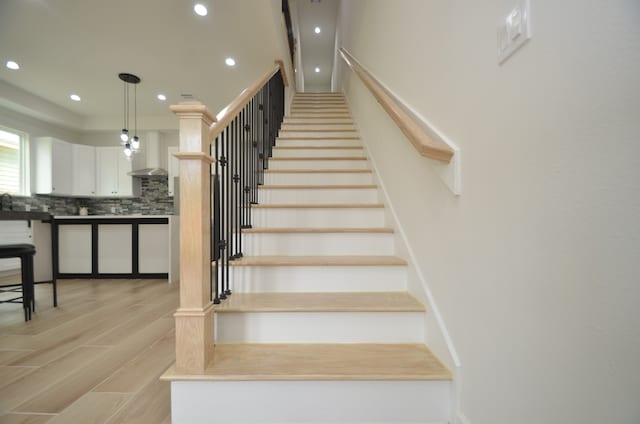 staircase with recessed lighting and wood finished floors