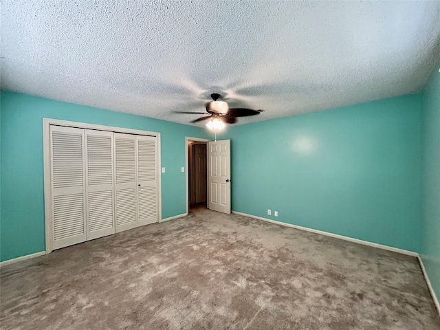 unfurnished bedroom with a textured ceiling, a closet, a ceiling fan, carpet flooring, and baseboards