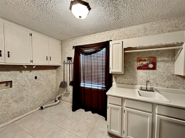 laundry area with light tile patterned floors, electric dryer hookup, washer hookup, a sink, and cabinet space