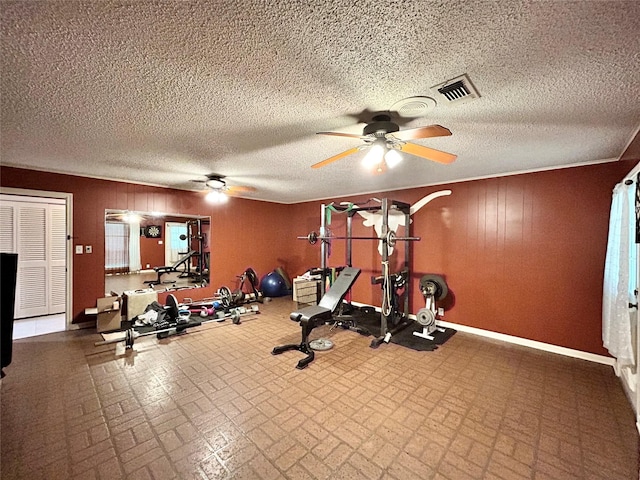 workout area with brick floor, baseboards, a ceiling fan, and visible vents