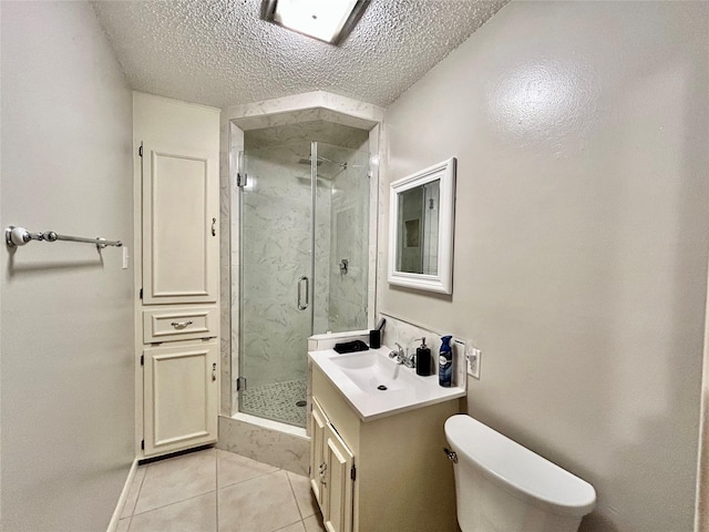 bathroom featuring toilet, a textured ceiling, vanity, a marble finish shower, and tile patterned flooring