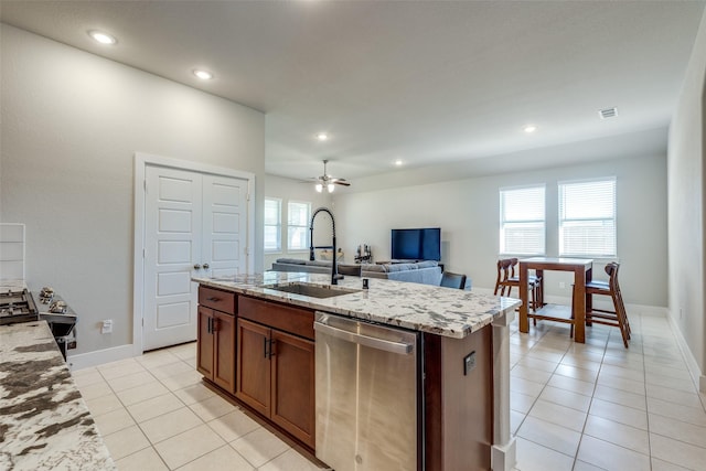 2411 Ocean Key Dr, La Marque, TX 77568 - kitchen with light tile patterned floors, light stone countertops, a wealth of natural light, dishwasher, and a sink