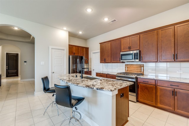 2411 Ocean Key Dr, La Marque, TX 77568 - kitchen with light tile patterned floors, visible vents, appliances with stainless steel finishes, arched walkways, and a sink