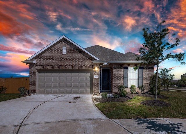 2411 Ocean Key Dr, La Marque, TX 77568 - ranch-style house featuring a garage, roof with shingles, a front lawn, brick siding, and driveway