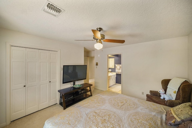 bedroom with a ceiling fan, a textured ceiling, visible vents, and a closet