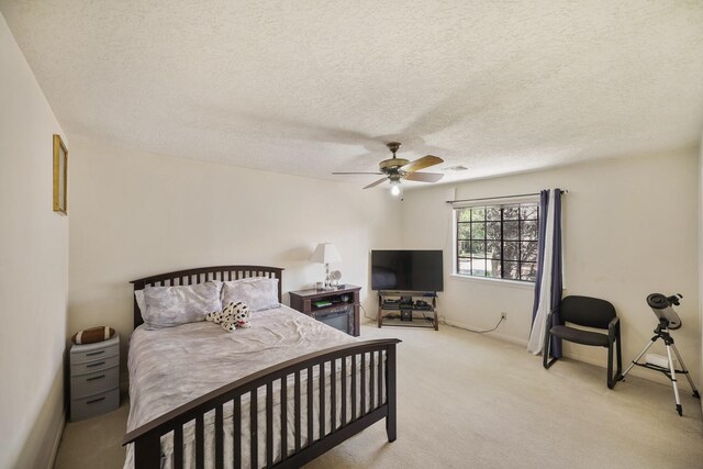 bedroom with a ceiling fan, a textured ceiling, light colored carpet, baseboards, and visible vents