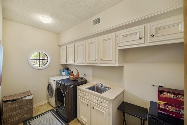 laundry room with a textured ceiling, a sink, visible vents, independent washer and dryer, and cabinet space