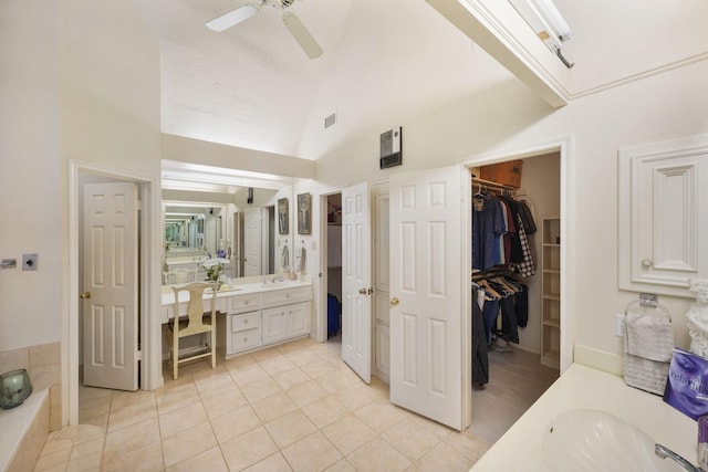 bathroom with high vaulted ceiling, a spacious closet, vanity, ceiling fan, and tile patterned flooring