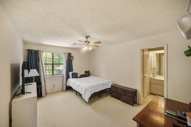 carpeted bedroom featuring a ceiling fan, ensuite bath, and a textured ceiling