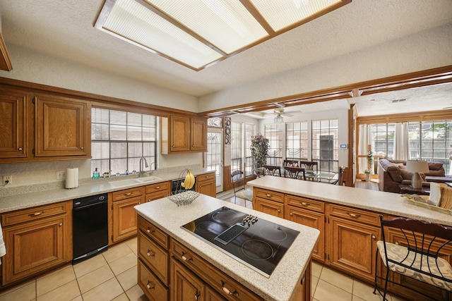 kitchen with black appliances, a sink, and light countertops