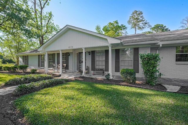 1535 Spring Hills Dr, Spring, TX 77386 - ranch-style house featuring brick siding, a front yard, a porch, and roof with shingles
