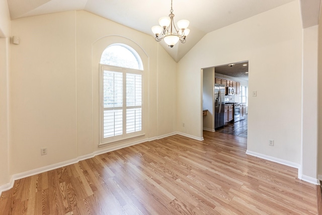 23222 Drywood Crossing Ct, Spring, TX 77373 - unfurnished room with vaulted ceiling, a chandelier, light wood-style floors, and baseboards