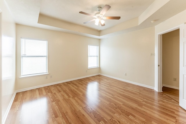 23222 Drywood Crossing Ct, Spring, TX 77373 - unfurnished room with light wood-style flooring, a raised ceiling, ceiling fan, baseboards, and a smoke detector