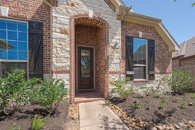view of exterior entry with stone siding and brick siding