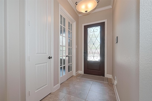 foyer featuring baseboards, ornamental molding, and a textured wall