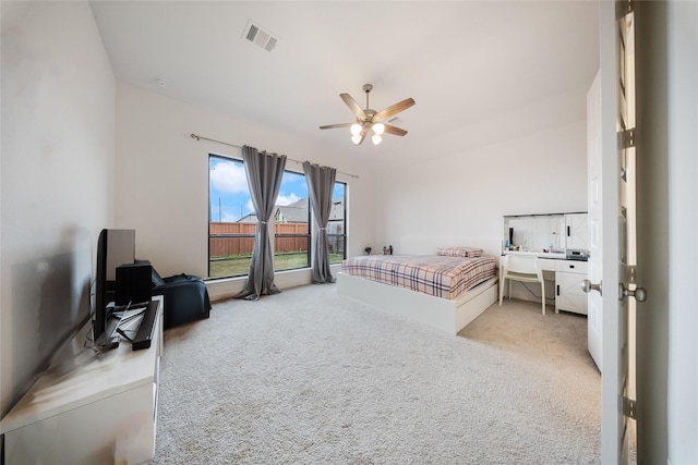 bedroom with visible vents, ceiling fan, light colored carpet, and vaulted ceiling