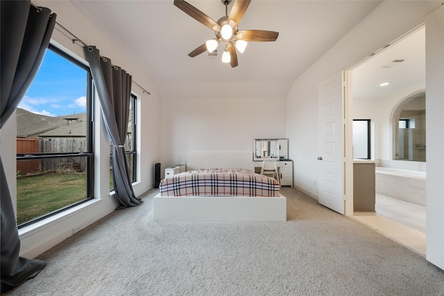 bedroom with connected bathroom, multiple windows, carpet flooring, and vaulted ceiling