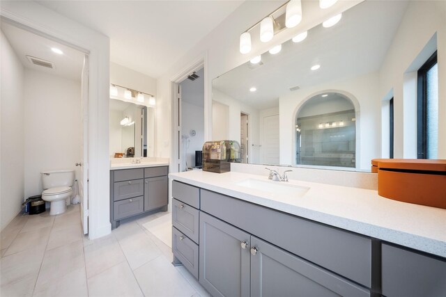 bathroom featuring a sink, toilet, a stall shower, visible vents, and tile patterned flooring