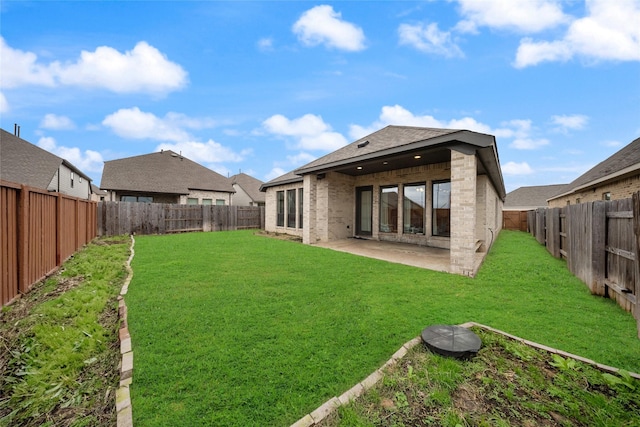back of house featuring a lawn, a patio, and a fenced backyard