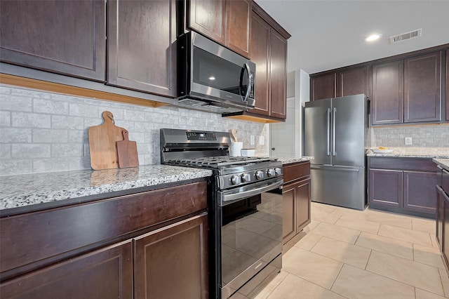 23806 Naples Shore Dr, Katy, TX 77493 - kitchen featuring dark brown cabinets, visible vents, appliances with stainless steel finishes, and light stone counters
