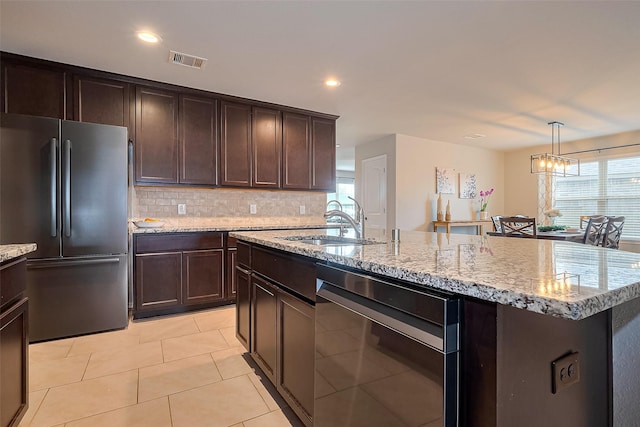 23806 Naples Shore Dr, Katy, TX 77493 - kitchen with freestanding refrigerator, dark brown cabinets, visible vents, a sink, and backsplash