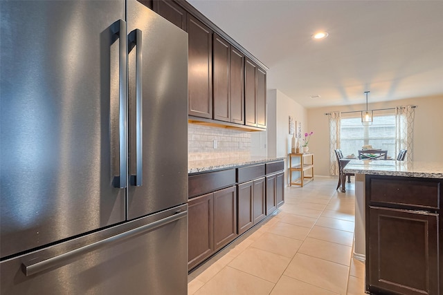 23806 Naples Shore Dr, Katy, TX 77493 - kitchen with freestanding refrigerator, backsplash, light tile patterned floors, and dark brown cabinetry