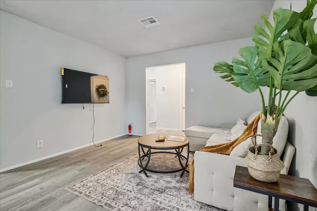 living area featuring wood finished floors, baseboards, and visible vents