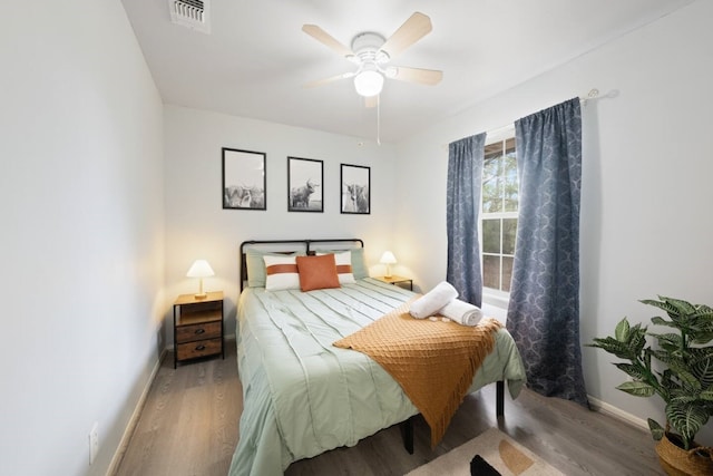bedroom with wood finished floors, baseboards, a ceiling fan, and visible vents