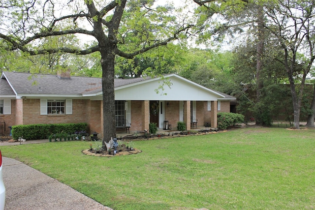ranch-style house with brick siding, a chimney, a porch, and a front yard