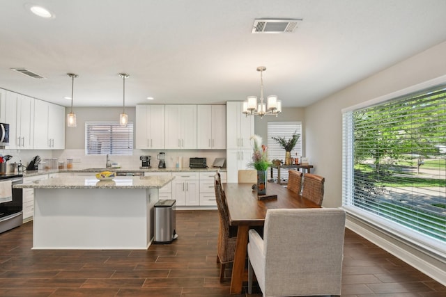 1006 Glacier Hill Dr, Houston, TX 77077 - kitchen with dark wood-style floors, a sink, appliances with stainless steel finishes, a kitchen island, and decorative backsplash