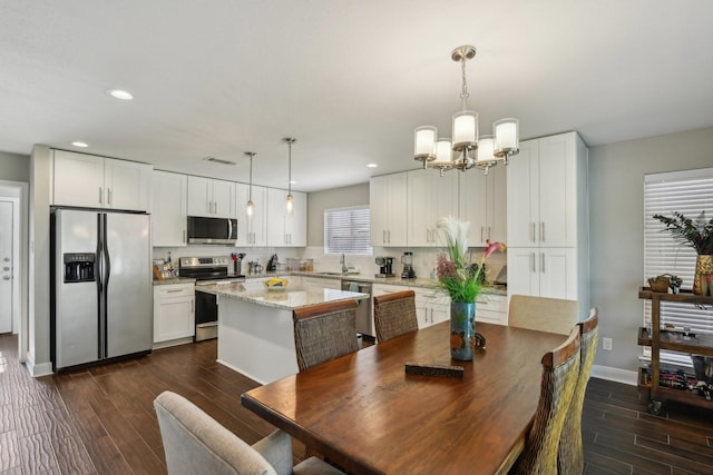 1006 Glacier Hill Dr, Houston, TX 77077 - dining area featuring a chandelier, dark wood finished floors, baseboards, and recessed lighting