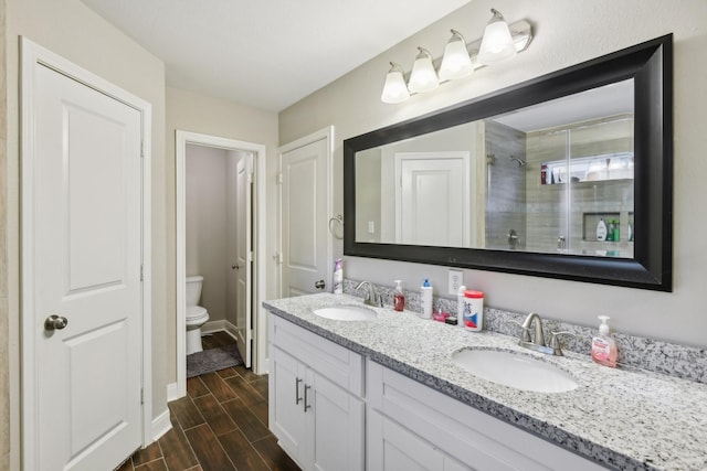 1006 Glacier Hill Dr, Houston, TX 77077 - full bath featuring double vanity, toilet, wood finish floors, baseboards, and a tile shower